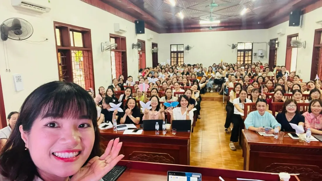 Cô Thuý Liễu chụp cùng hội trường giáo viên đang cầm bướm giấy tự làm